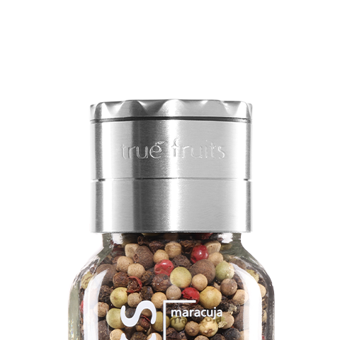 true fruits - Upcycling true fruits Flasche mit Flaschenaufsatz, gefüllt mit Pfeffer vor weißem Hintergrund